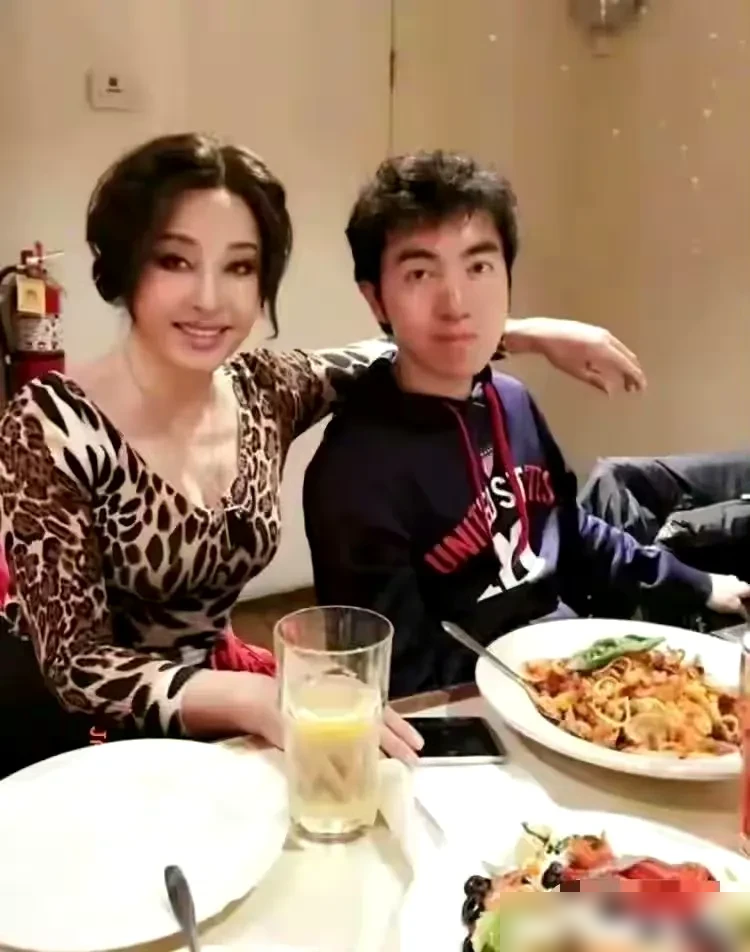 刘晓庆私下真是太疯狂了

穿着豹纹衫，紧紧依偎着小鲜肉。

颜值回春，娇艳动人，