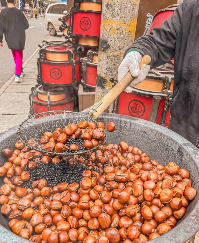 这也要讹人？北京东城，大妈逛街时看到一炉板栗刚出炉，直接上去拿了一颗往嘴里塞，结