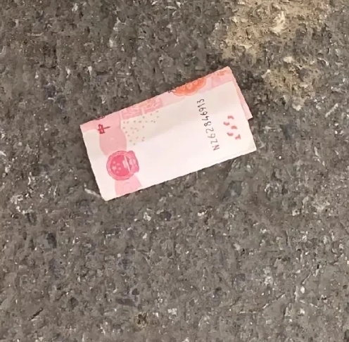 在医院门口，看到地上有钱，但是人来人往，大家就像没有看到一样。我想捡，但是脸皮薄