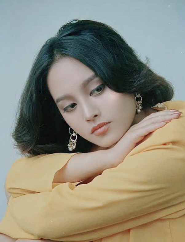 年轻时的宁静才是真的美！镜头下的她画着淡淡的妆容，五官立体，气质独特。她身穿黄色