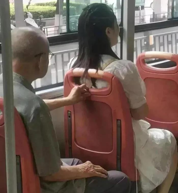 在一趟公交车上发生了这样一幕：一位老人坐在座椅上，他用手扶着前面的椅背。但令人注