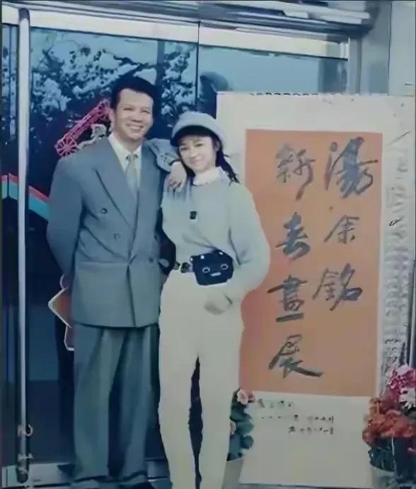 这是汤唯年轻时，在父亲的书画展上，与父亲的一张合影。
那时的汤唯看起来很年轻，很