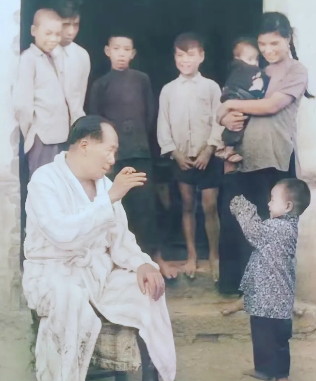 50年代末，毛主席在湖南游完泳之后，上岸休息，与小朋友在逗趣。

他满腿是泥，穿