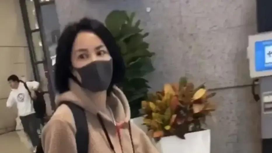 55岁王菲素颜现身机场，驼色卫衣搭配黑色紧身裤，看起来像25岁