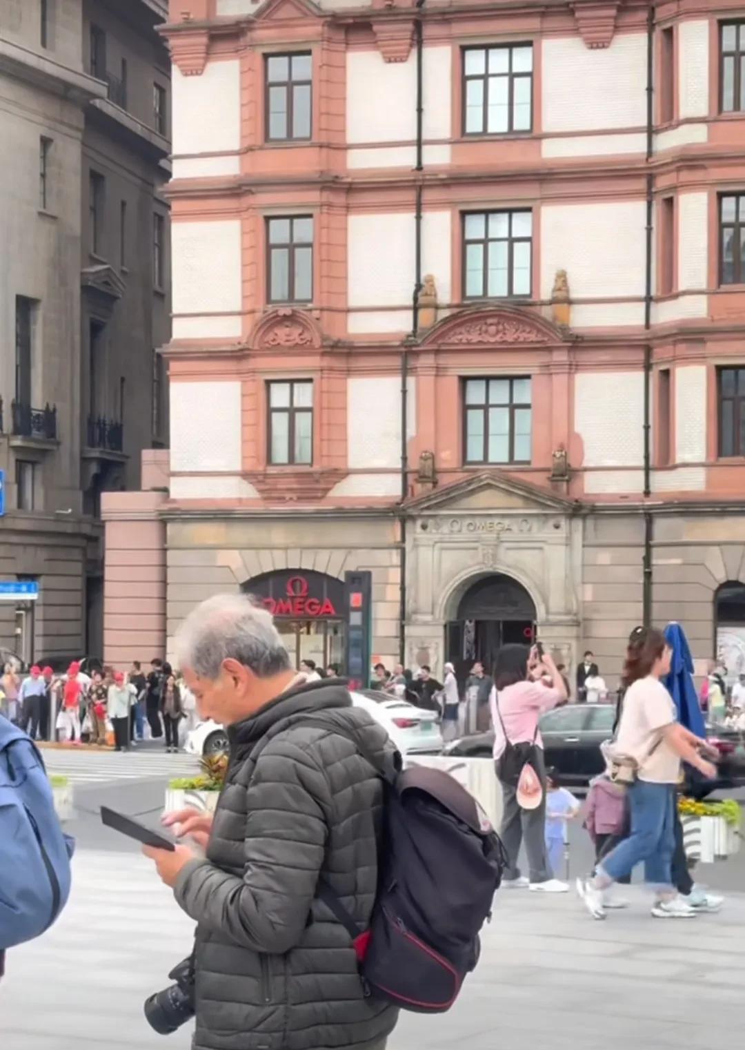上海外滩上来旅游的外国人也是人山人海，其中这位穿黑色羽绒服的老外格外显眼，6月份