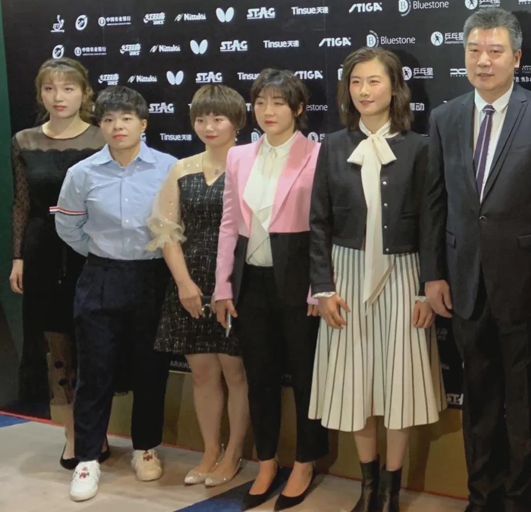 2019年世界乒坛盛典上，中国女子乒乓球队全体队员合影，个个容光焕发，衣着风格各