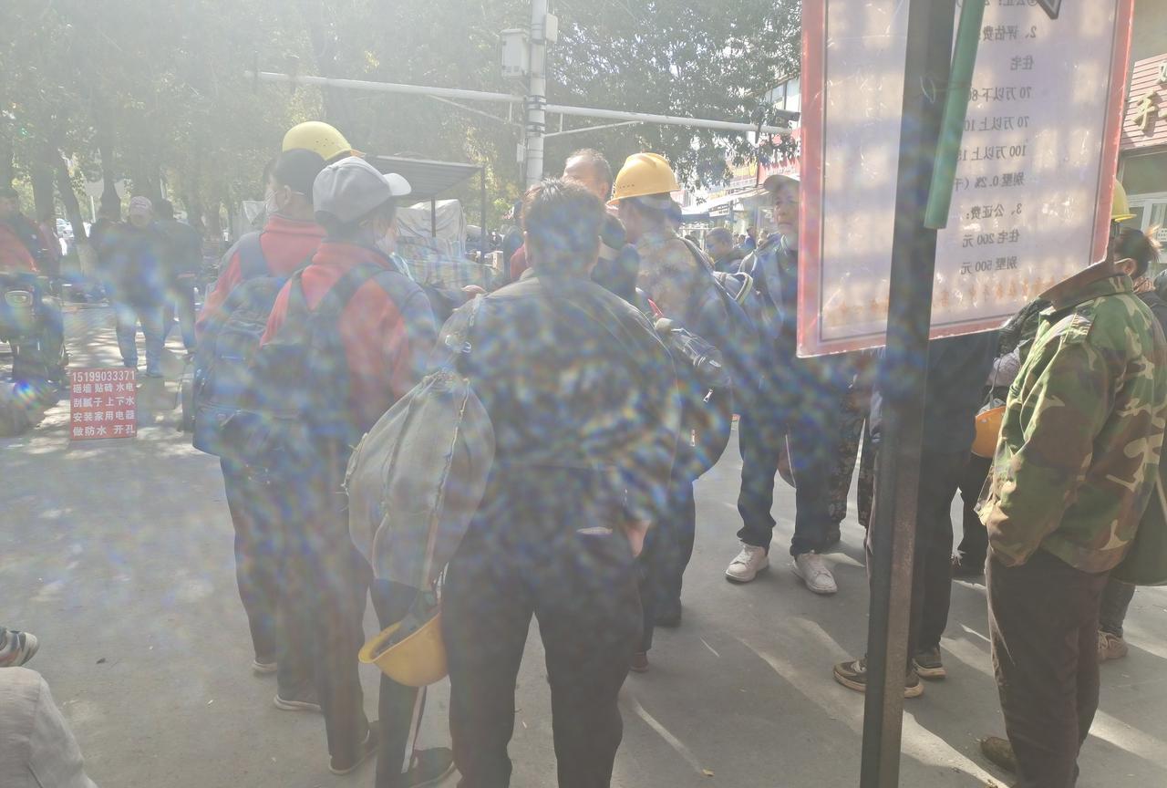 临近中午了，乌鲁木齐市天津南路自发劳务市场10几个务工人员在讨论着什么？有的心情