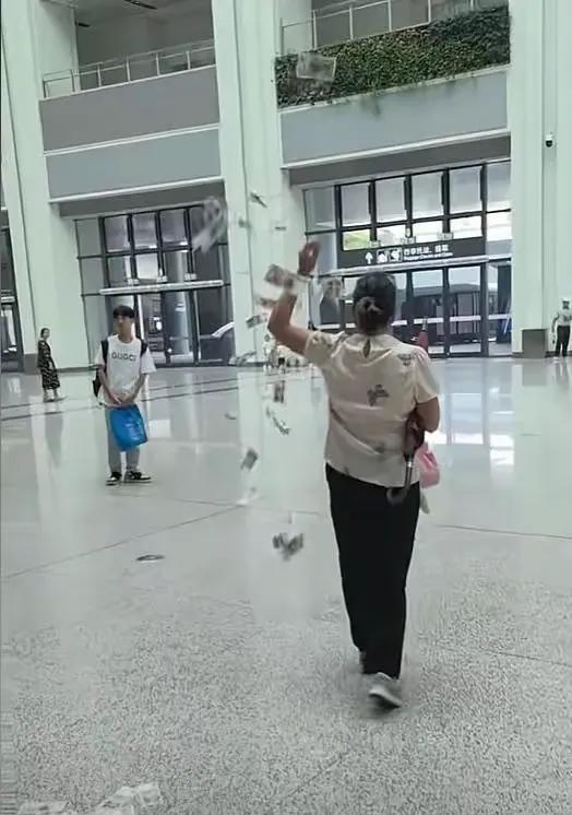 这名女子在某高铁站撒钱，感到莫名其妙：
1、她为什么要撒钱？
2、如果碰到的话能