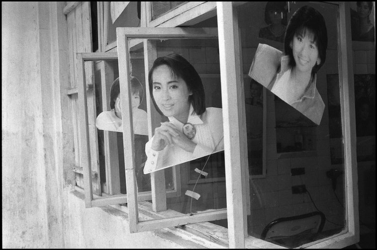 1989年，厦门的发廊，窗子上贴着大幅美女照。 