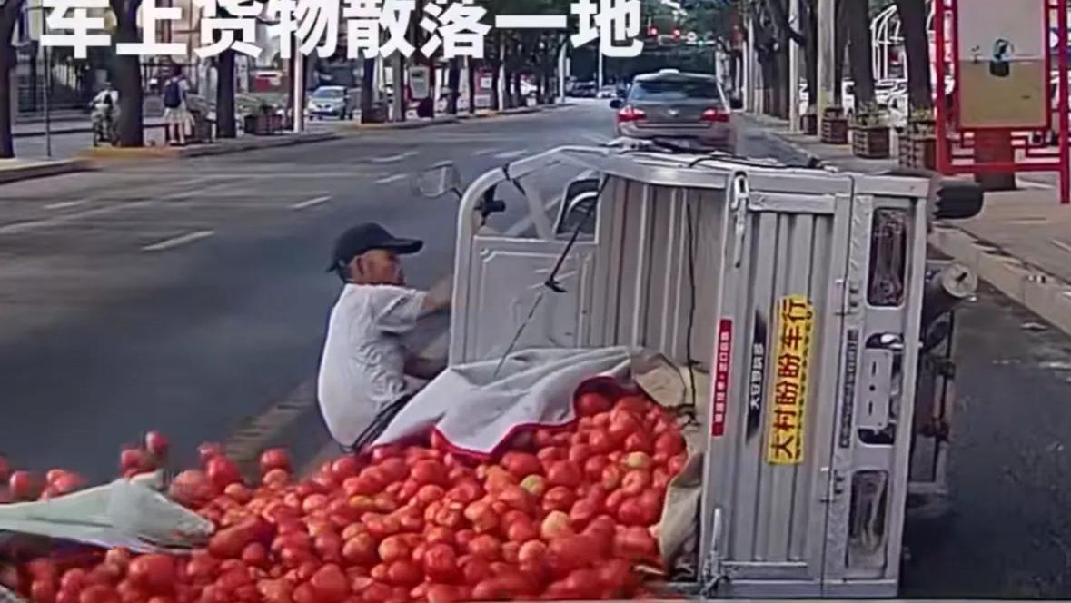 大爷骑三轮车不慎侧翻，西红柿洒一地，路人伸出援手