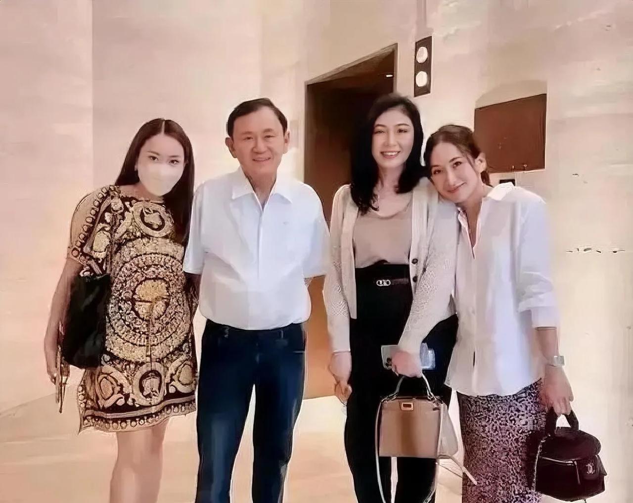 泰国人他信与妹妹英拉及两个女儿的亲情合影。
从照片中可以看到，他信家族生活优渥不