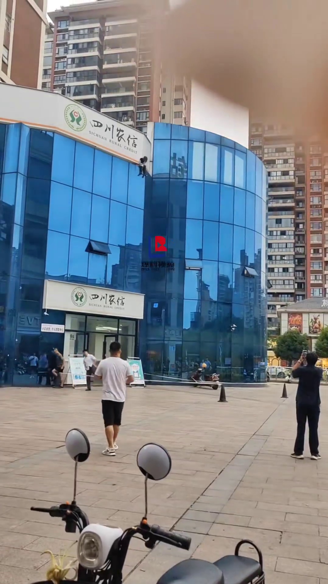 一女孩坐在银行顶楼欲跳楼，拍摄女称：生命只有一次，要珍爱生命