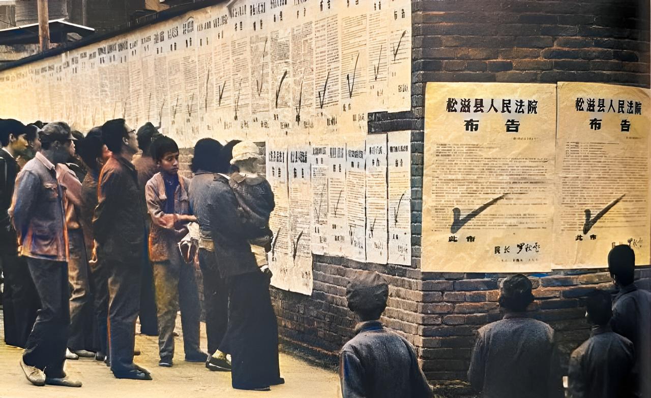 这是1983年“严打”期间，松滋县人在街头认真观看贴在墙上的一张张的布告。每张布