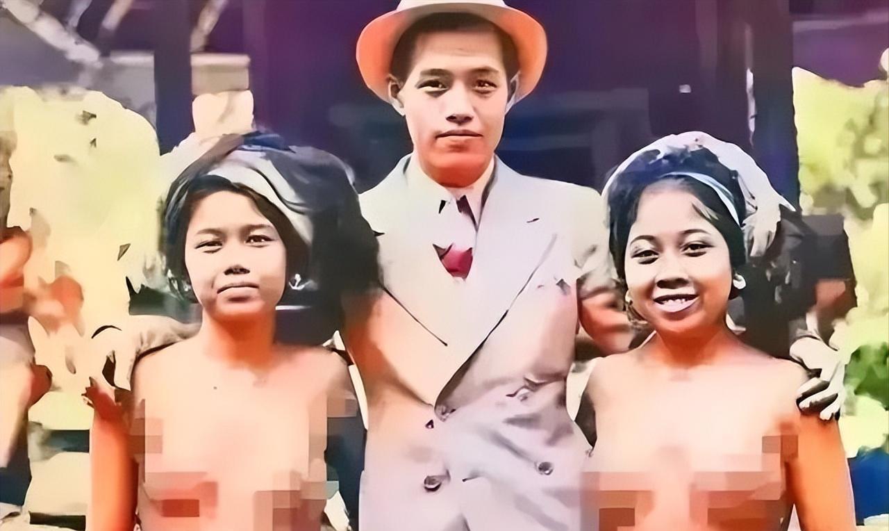1932年，一名去巴厘岛游玩的男子，搂着两名原住民美女拍照。两位美女笑得非常自然