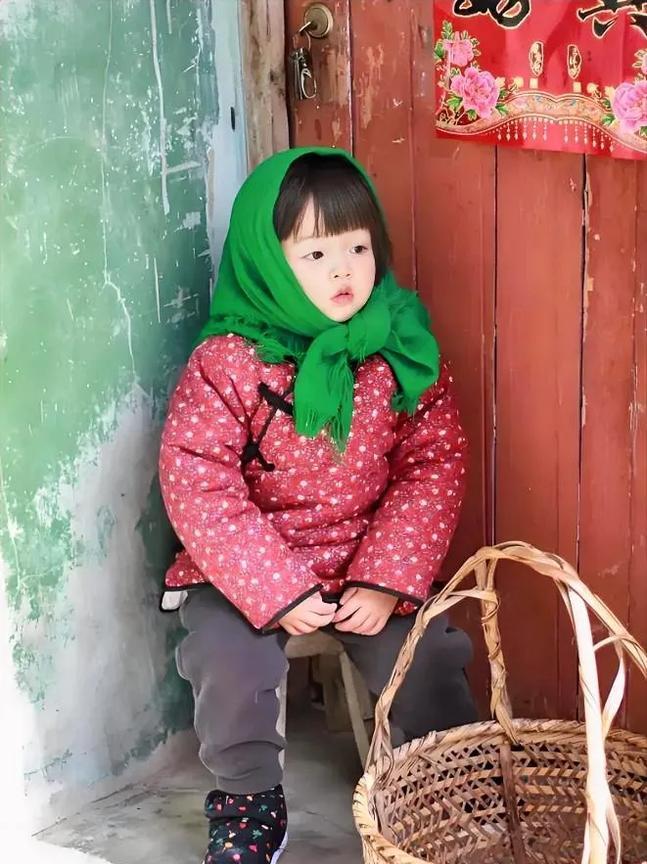 小姑娘坐在家门口盼妈妈回家，她有可能是肚子饿了等妈妈回家做饭。