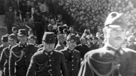 1937年，一个日本军官在大连“庆祝攻占南京大捷”会上，正在伸直头鞠躬行礼时，突