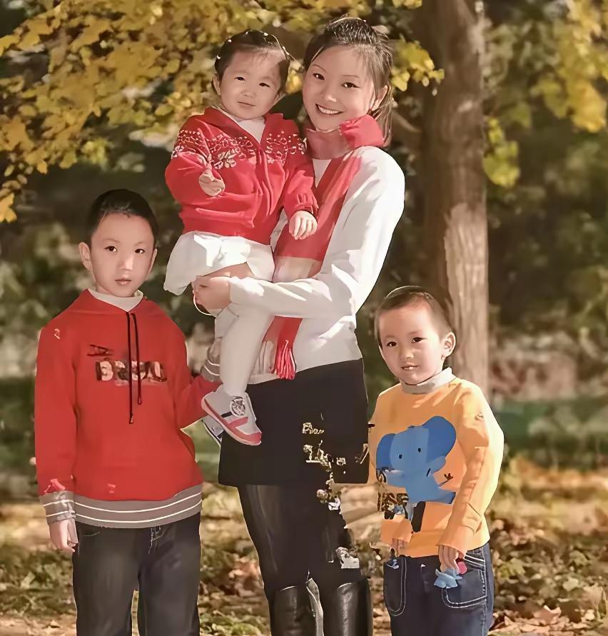 这是张艺谋妻子陈婷年轻时，与三个孩子的合影照。
照片中的陈婷抱着女儿，两个儿子站