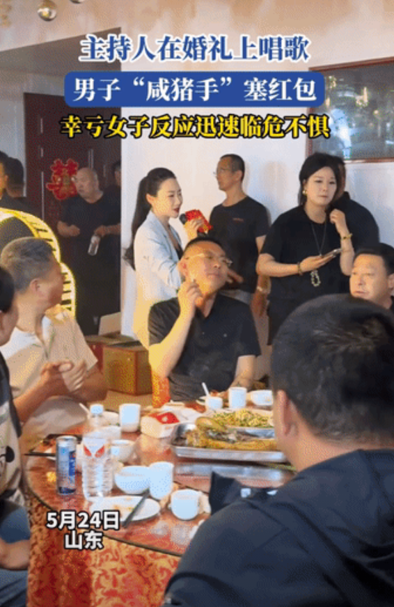 玩过火了！主持人在新人的婚礼上唱歌，没想到，一名男子竟然从背后搂住主持人，要将红