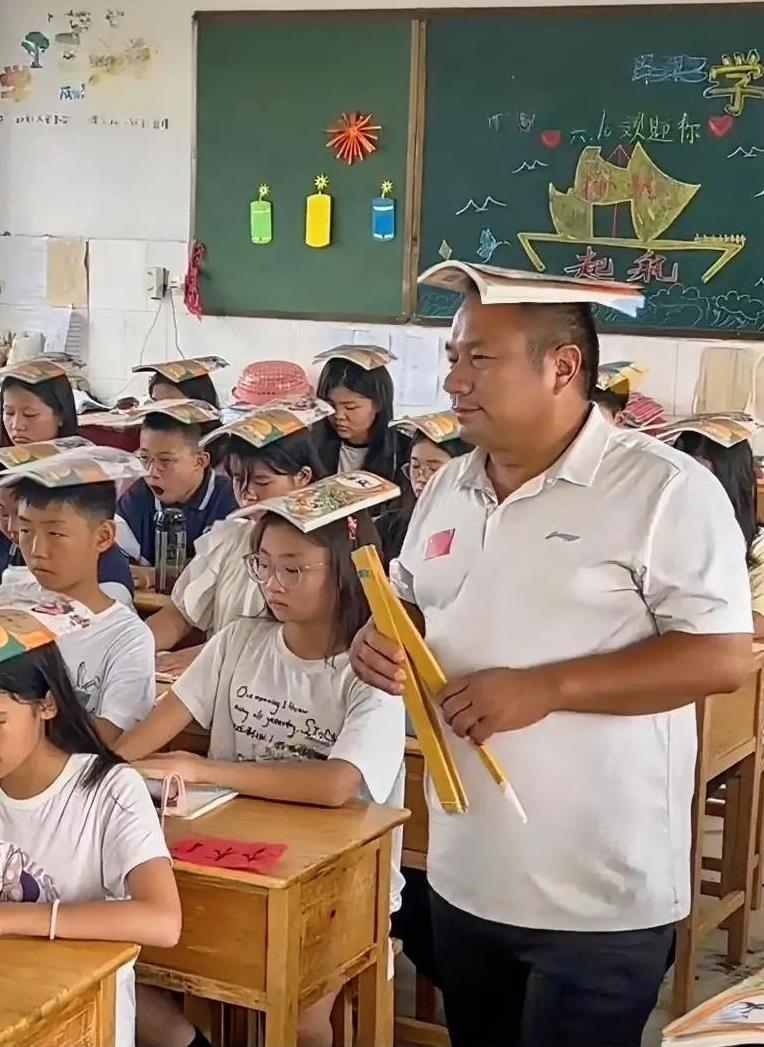 一位男老师头顶课本走进了教室，而进去以后才发现，全班所有学生都一样，全是头顶课本