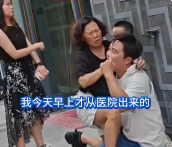 南京街头，一男子跪在水泥地上，向劈腿老婆连磕三个响头，哭喊：“我一天打两份工，从