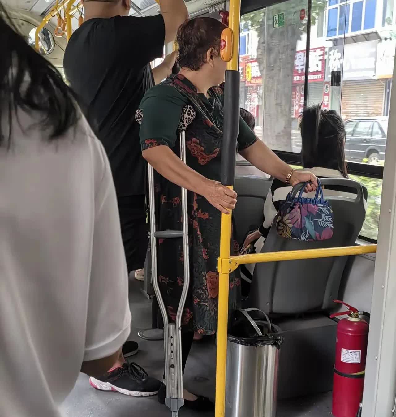 拄拐杖的阿姨穿花裙，攥着彩布包，紧紧抓扶手。窗外店铺刚苏醒，车内百态。你说谁会主