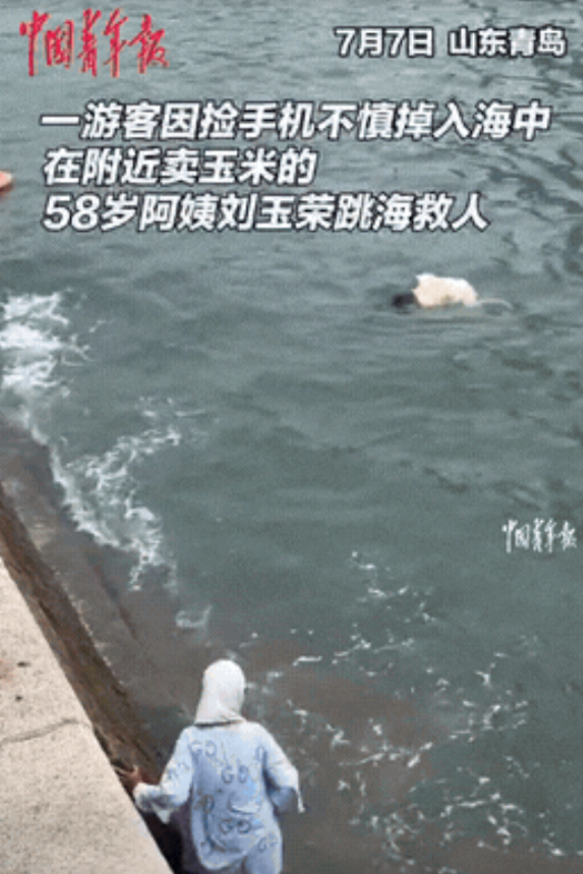 “这位大妈火了！”山东青岛，一女生岸边拍照，手机不小心掉入海中，捡手机被浪拍打进