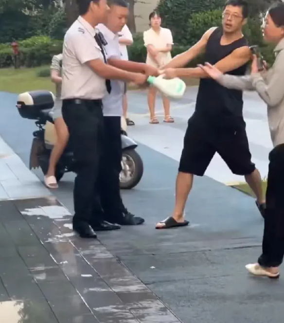 浙江金华。小区业主用浇绿化的水洗垫子，物业保安制止，业主不听劝阻，双方发生争执。