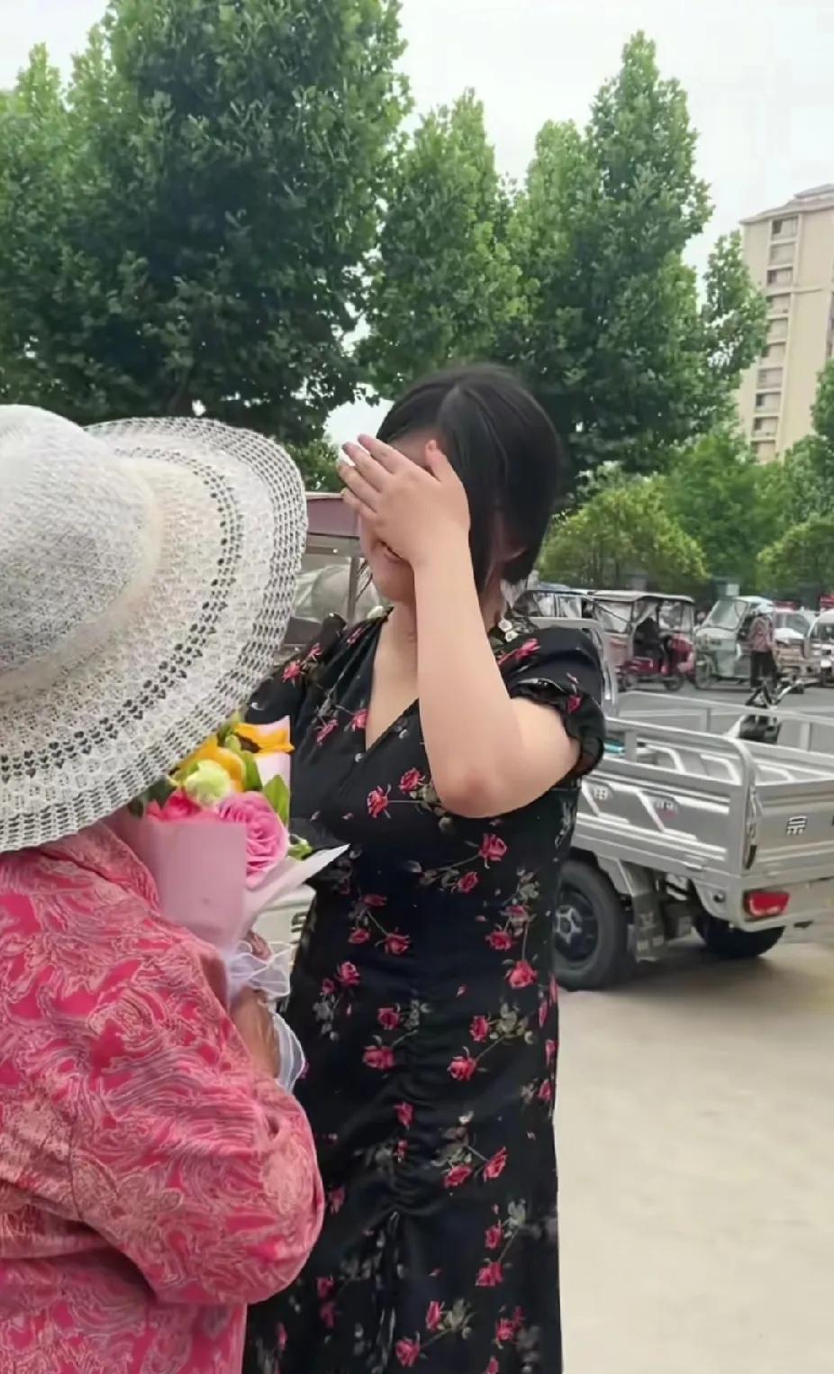 一位戴着草帽的白发老人，手捧鲜花突然岀现在女孩面前，看着老人，女孩瞬间就绷不住泪