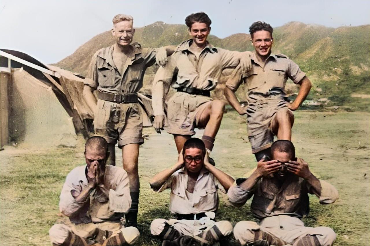 大家看这张照片。
在1945年7月，三名喜笑颜开的英国皇家空军士兵站在三名日本兵