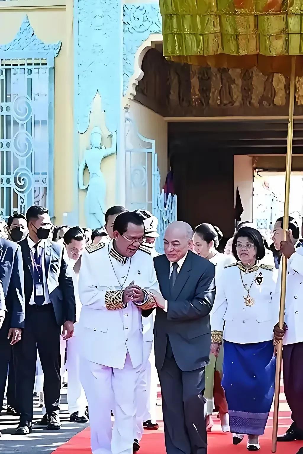 西哈莫尼国王搀扶着洪森，洪森却志得意满地走在红地毯上。不过，从现场情境来看，若不