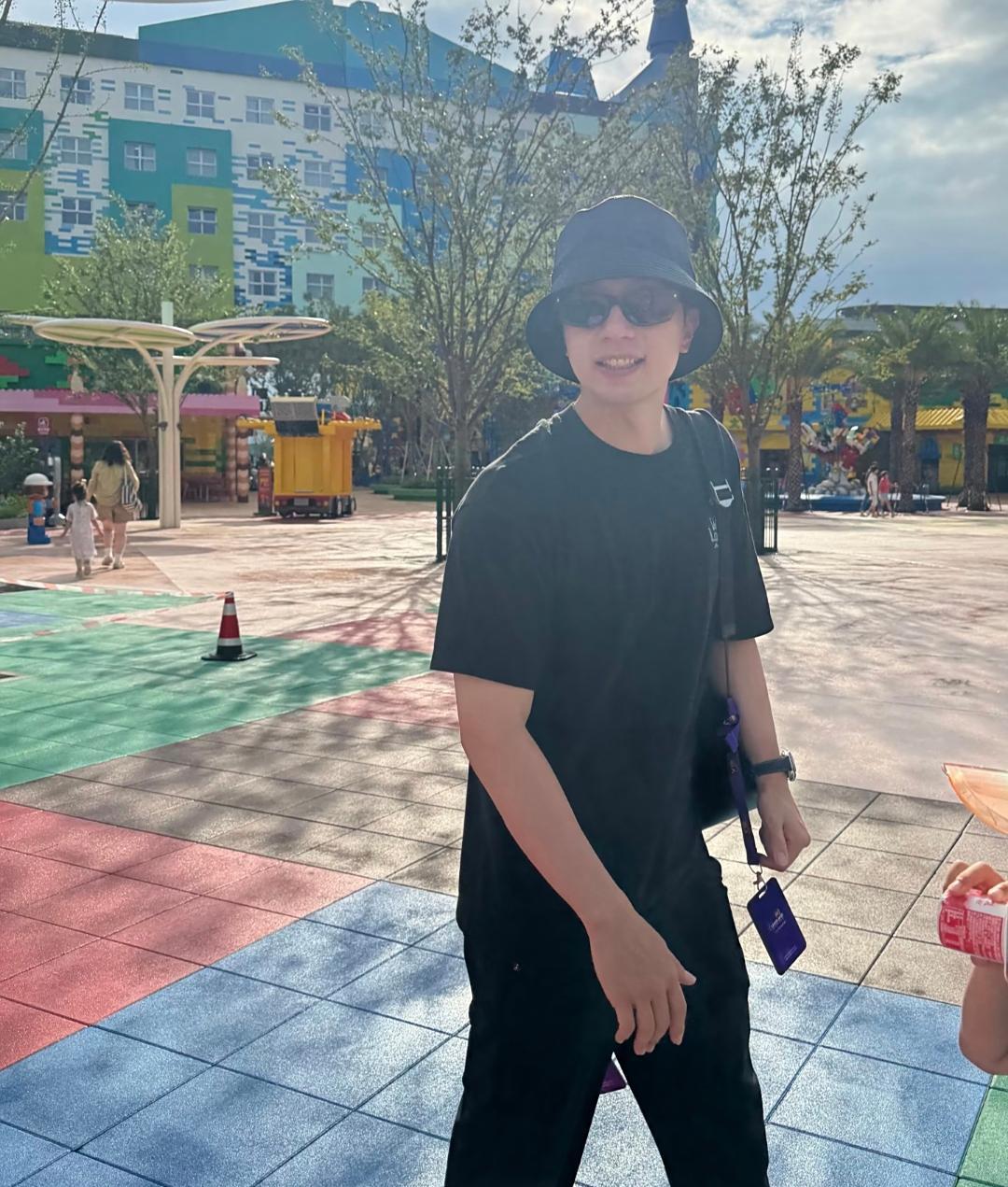 奥运冠军马龙和两个儿子在上海乐高乐园游玩，他穿了一身黑色，打扮很时尚，皮肤白皙，