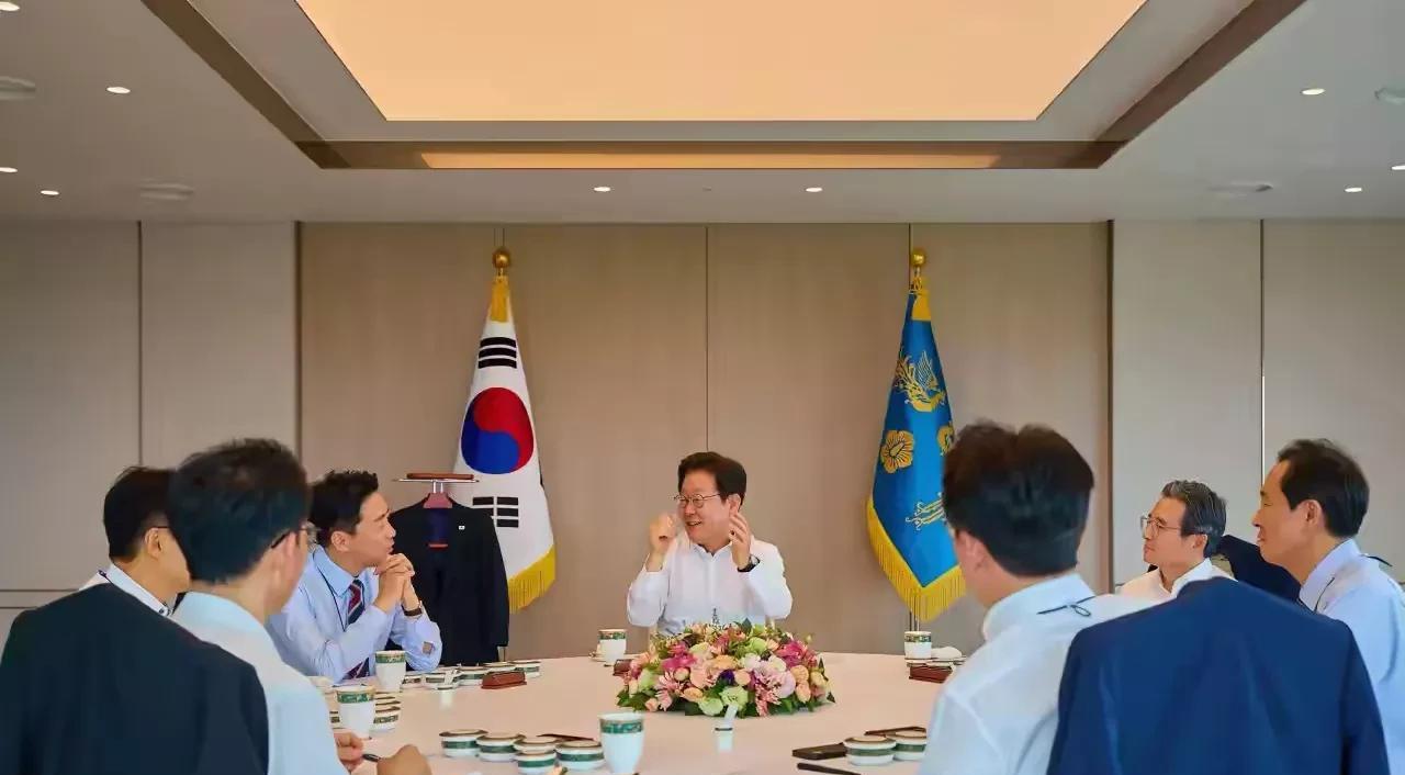 总统吃饭也是公事，李在明坐在主位，背后放置着韩国国旗及总统府旗，如同在内阁召开会