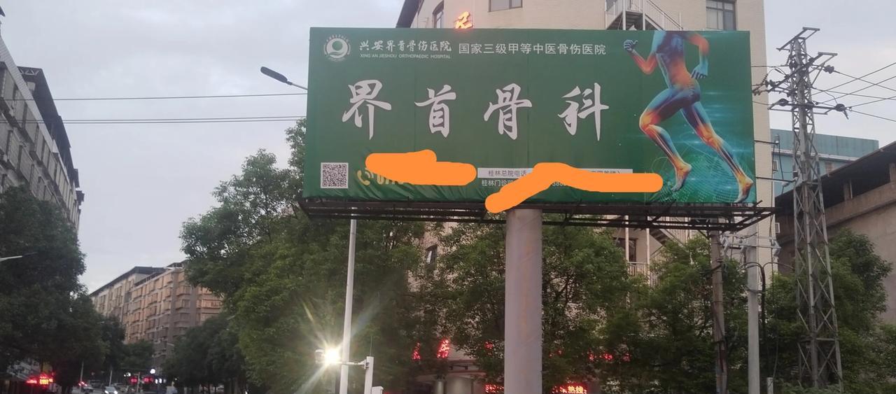 这里是东安县城同心路龙溪桥边，上面矗立的是广西桂林市兴安县界首镇医院的广告牌。