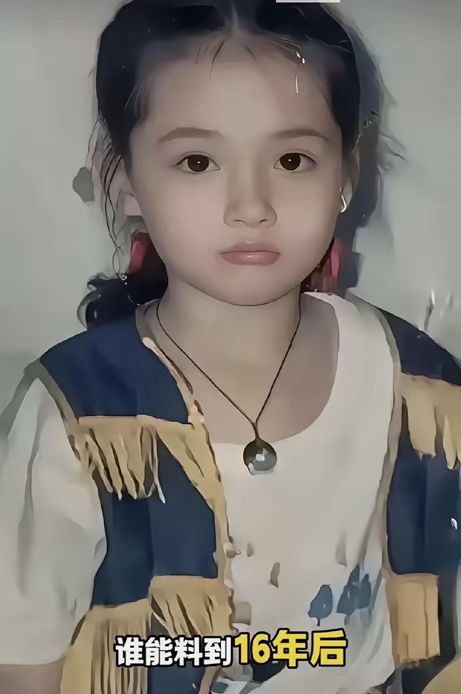 这是拍于九十年代的一张照片，照片中的小女孩扎着小马尾，留着一些小刘海，脸庞圆嘟嘟