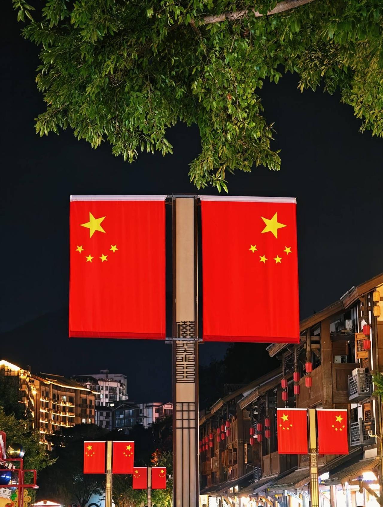 悬挂了很多五星红旗的重庆磁器口古镇，夜色更加迷人啦！9月27日晚上，我漫步古镇，