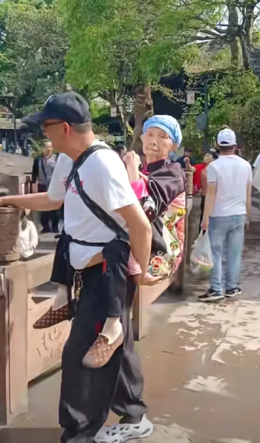 人来人往的景区里，人群中一名中年男子，不断引来游客的注目礼，直呼被这一幕感动了。