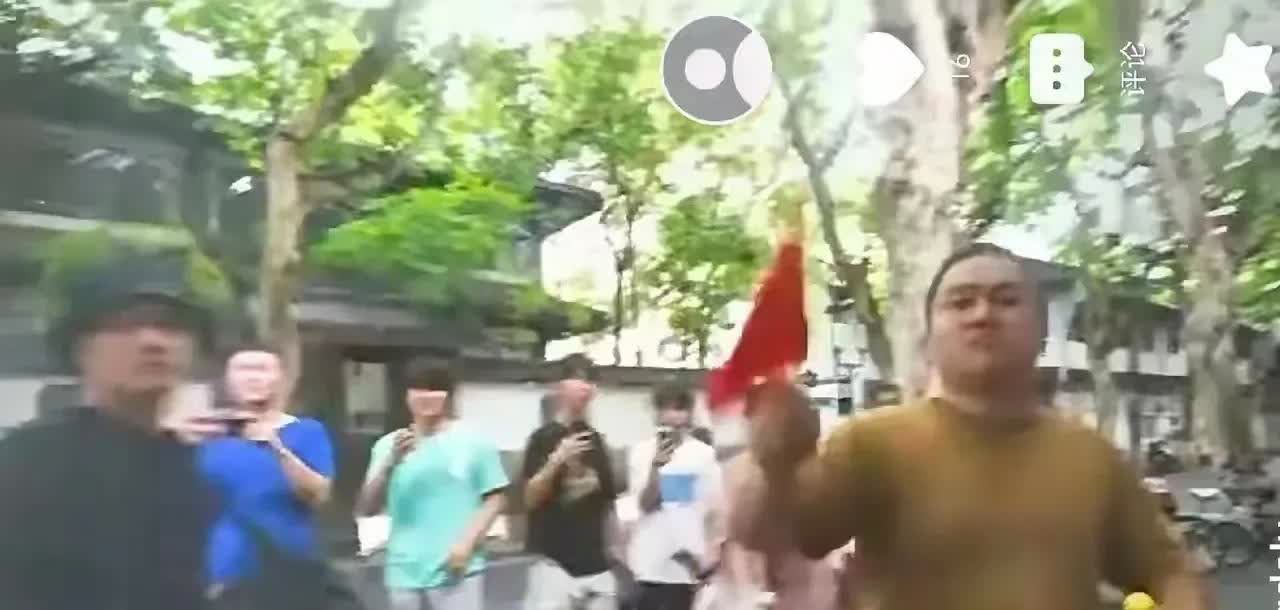 这是台湾网红“馆长”在杭州直播时遇到的一幕，在直播过程中，突然跳出来一名身穿浅黄