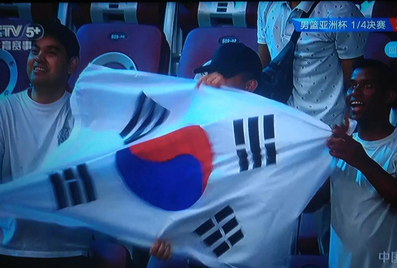 你看韩国球迷该有多疯狂。韩国队好不容易投进一个三分球，看台上的韩国抖着韩国旗吼翻