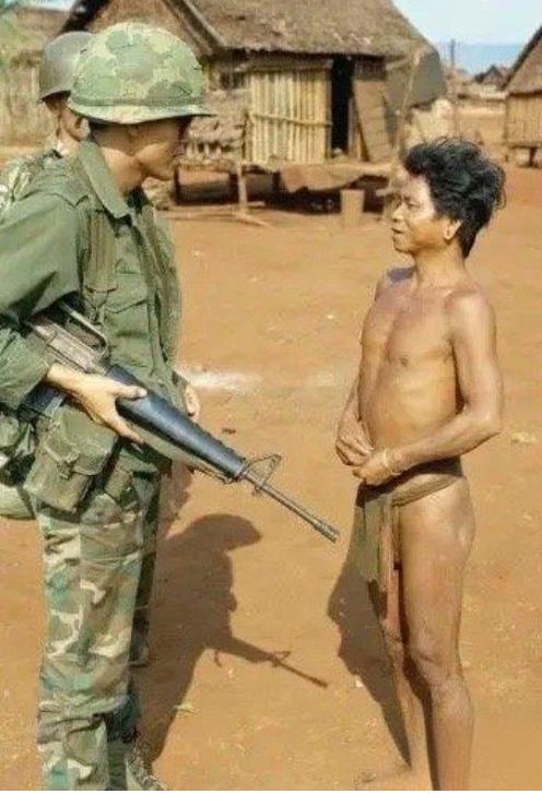 越战期间，越南中部高地难民营的一名美军士兵正在盘问一名土著部落人员。
对于这些越