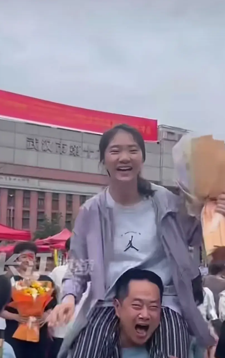 女孩高考完之后，陪考的父亲兴奋地把她顶在肩上，大喊终于考完了。女儿也大声地说太感
