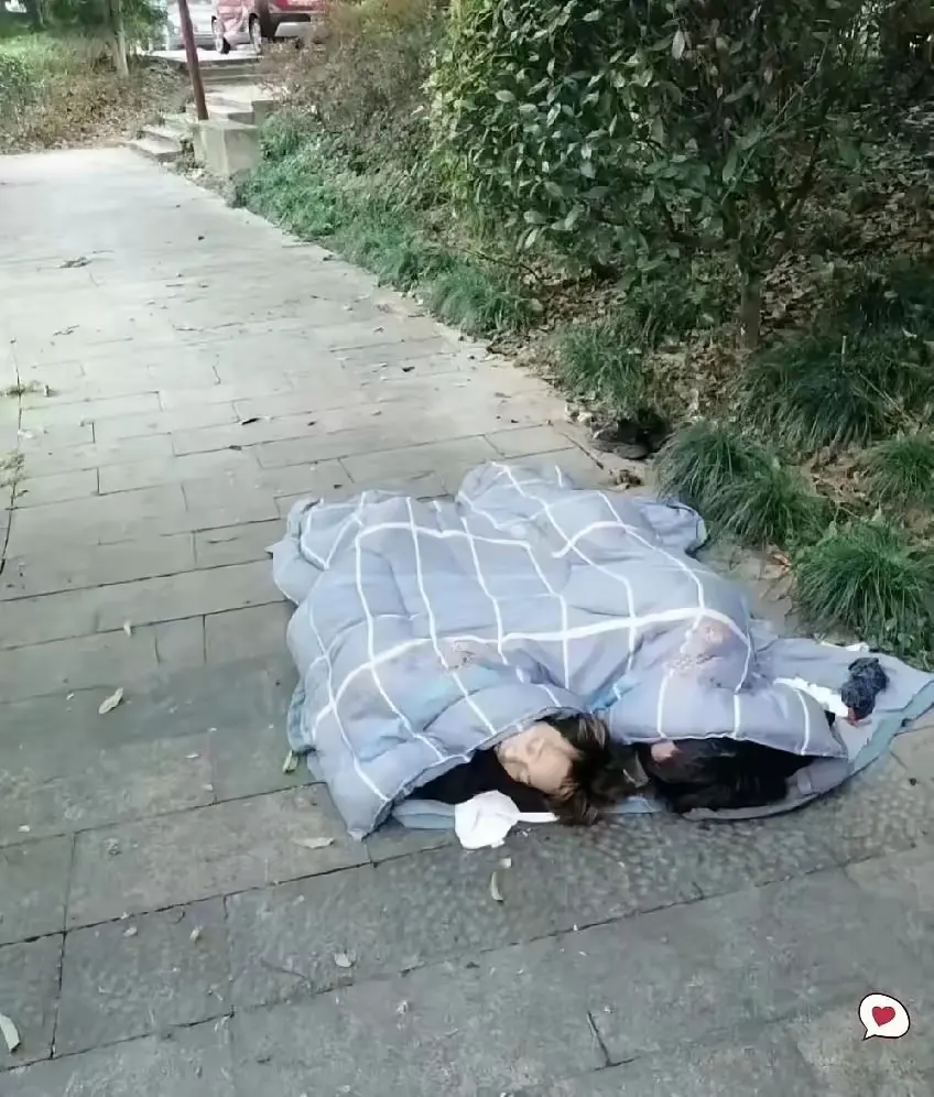 打工人的心酸谁懂啊！
​两个人裹着被子，睡在厂门口的水泥地上！