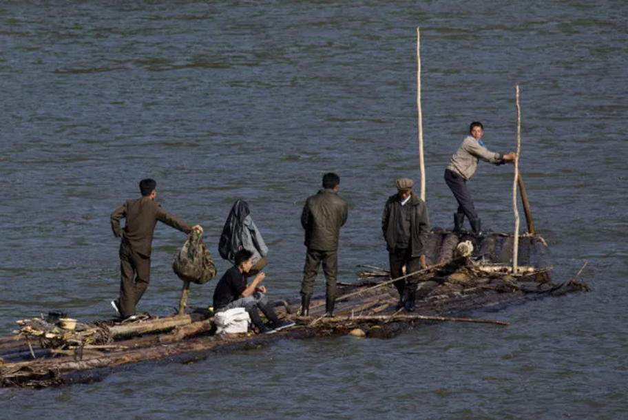 2017 年，朝鲜男子乘坐一艘由木头制成的木筏在鸭绿江中顺流而下。
