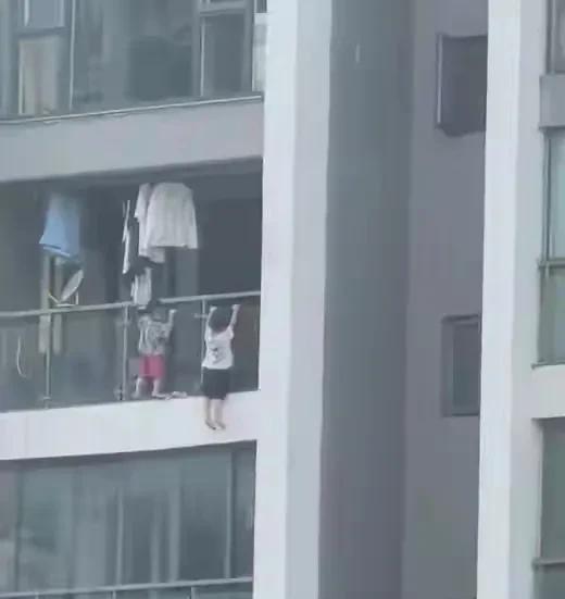 看到让人头皮发麻！两个淘气的幼童，在13楼窗外做引体向上，双脚悬空危险动作。
吓
