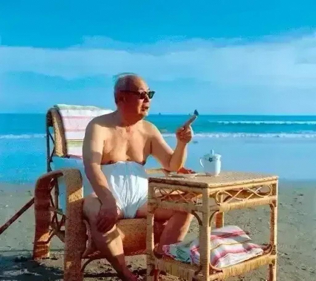 八十年代，叶剑英元帅在北戴河浴场休息，戴着墨镜，身后是蔚蓝的蓝天和大海。只见坐在