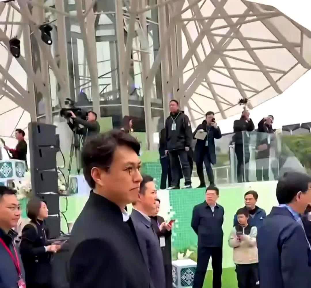 靳东现身南宁民歌湖，出席"广西三月三"开幕式，白衬衫配呢子大衣，眼镜一戴比领导更