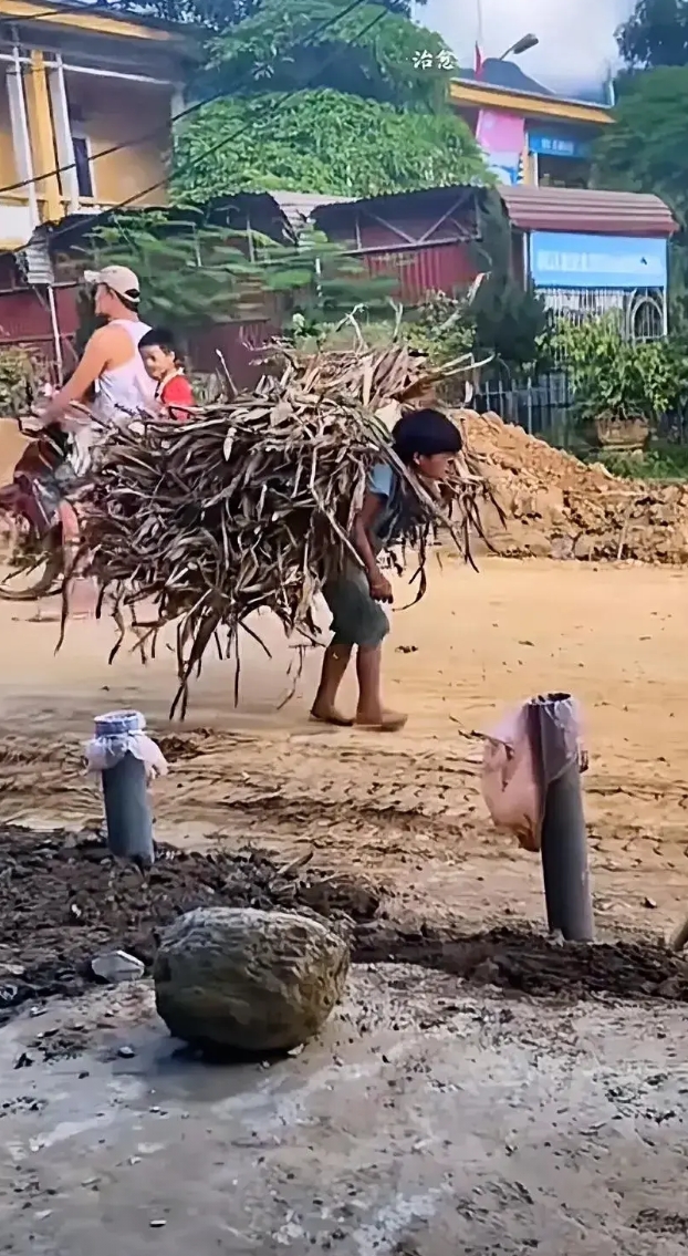 穷苦孩子早当家，看看这位孩子，这么小的年纪就在干苦力活，打着一双赤脚，走在乡村的