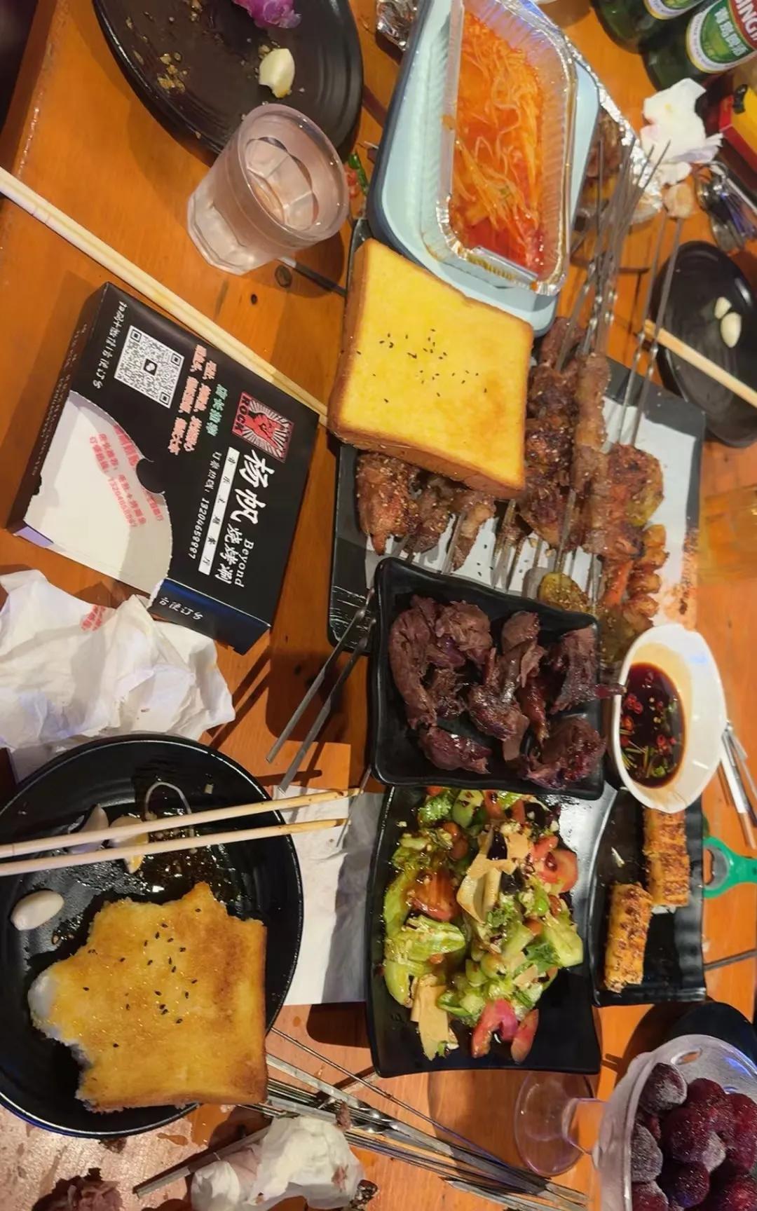 哈尔滨的秋天似乎来得早了些。夜色把路灯泡得发涨，碳火在铁架上噼啪作响。
烤串油脂