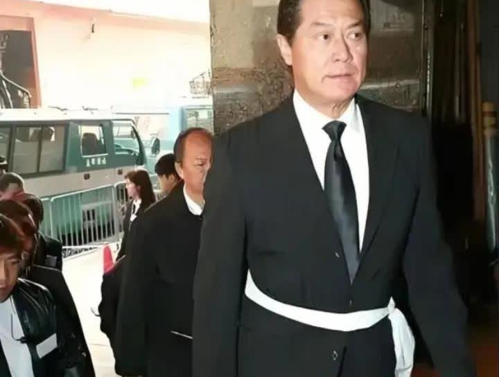 2009年，资深艺人林蛟葬礼上，邓光荣腰缠孝带出席时的一幕，他们亦师亦友