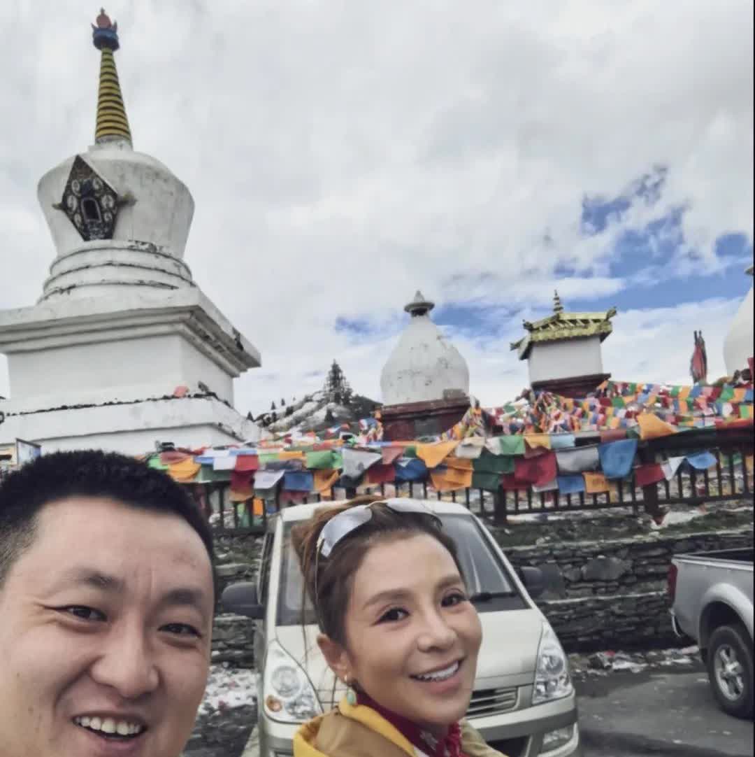 朱迅西藏旅游，素颜状态下黄色上衣显得皮肤发黄有点憔悴，笑容很勉强深邃的眼睛望着远
