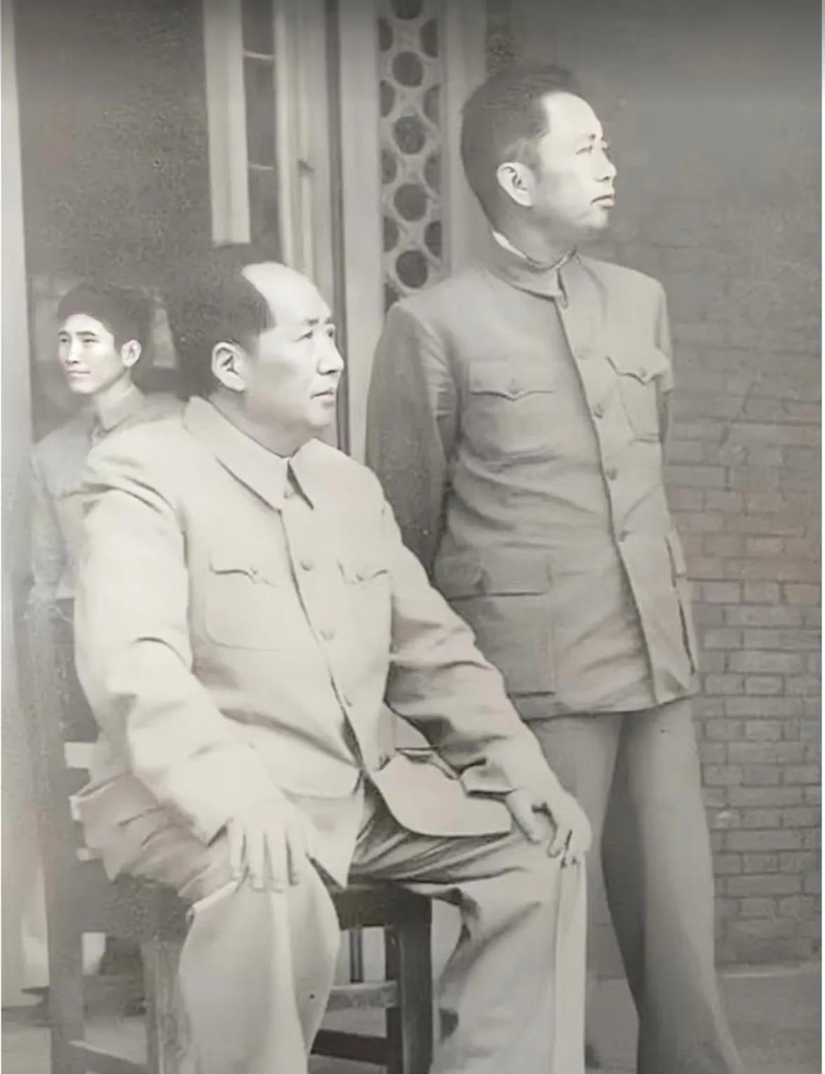 这张拍摄于上世纪50年代的照片中，伟人身着灰色中山装，脚踏黑皮鞋，端坐木椅上，腰